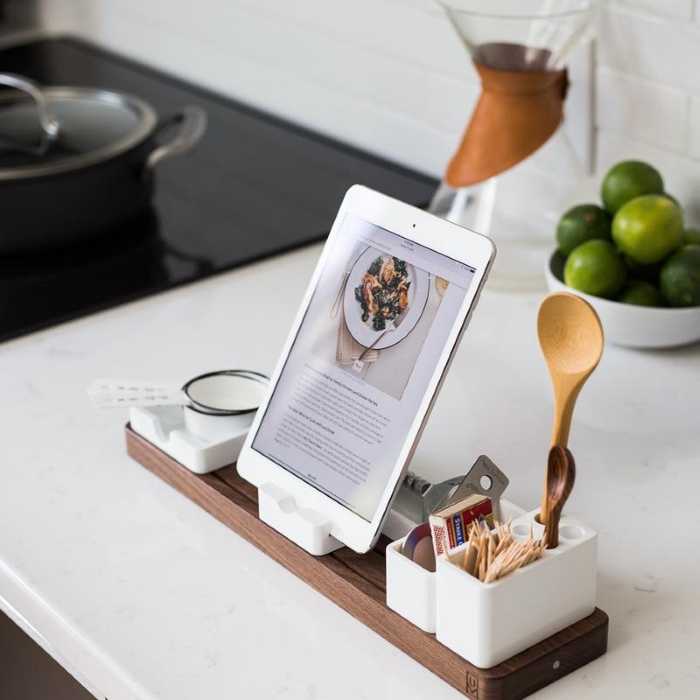 Modern kitchen counter with a wooden tablet stand, wooden spoon, and coffee setup in a minimalist and cozy style.