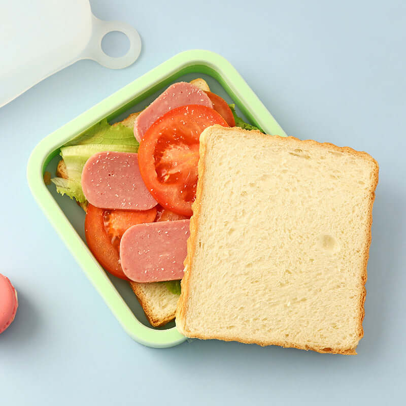 Open sandwich with bread, salami, and tomatoes on a light blue background