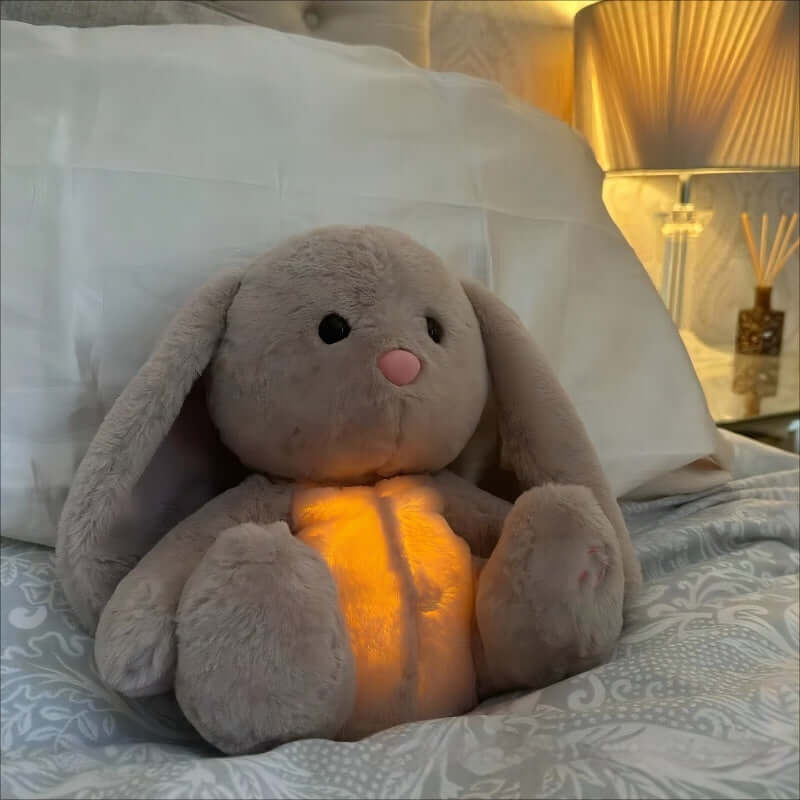 Soft breathing bunny plush toy beside sleeping baby