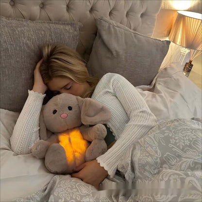 Baby cuddling breathing bunny toy during naptime