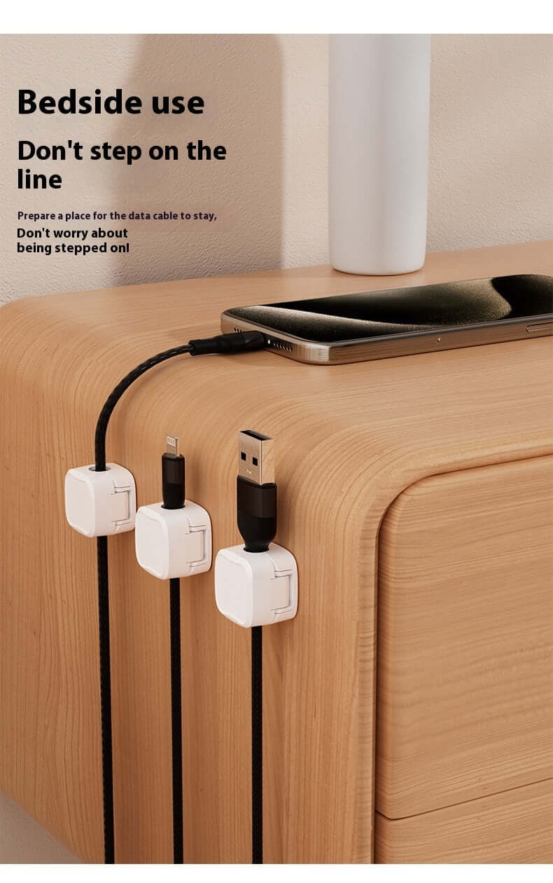 Magnetic cable holder mounted on side of wooden table