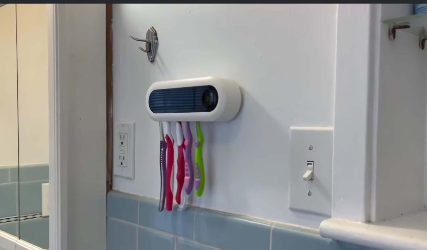 Wall-mounted toothbrush holder with colorful toothbrushes in a bathroom setting.